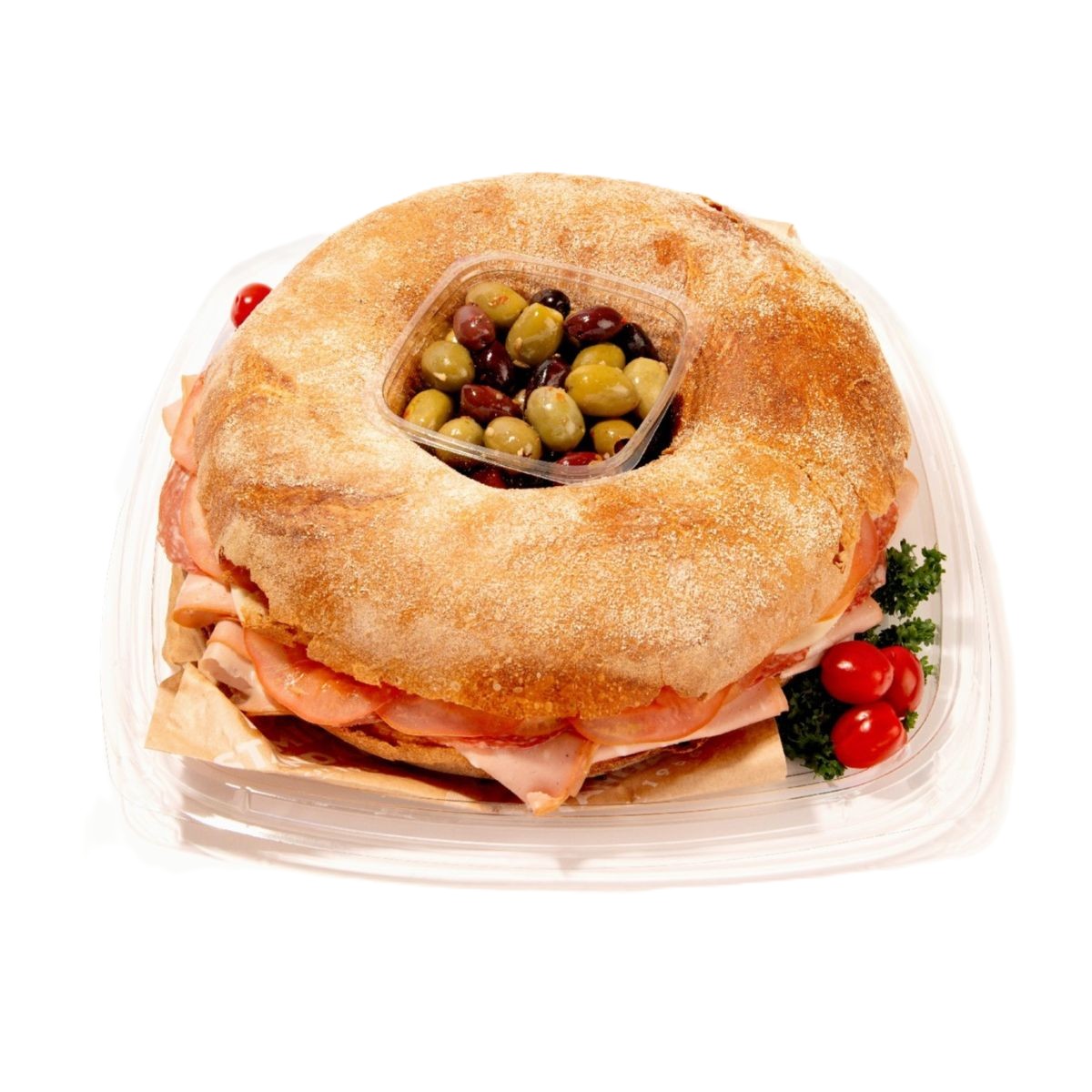 Ring-shaped muffaletta sandwich tray with deli meats, cheese, central olive mix, and cherry tomatoes garnish.